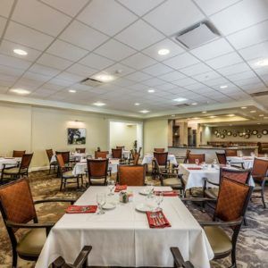 A spacious and elegant dining room with multiple tables set for guests.