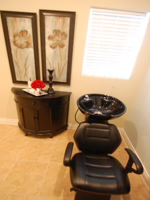 A cozy salon space featuring a hair washing station with a chair and sink.