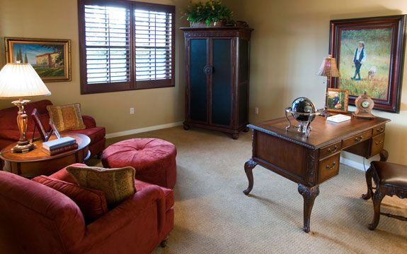 A cozy home office with a desk, chair, and natural light from the window.