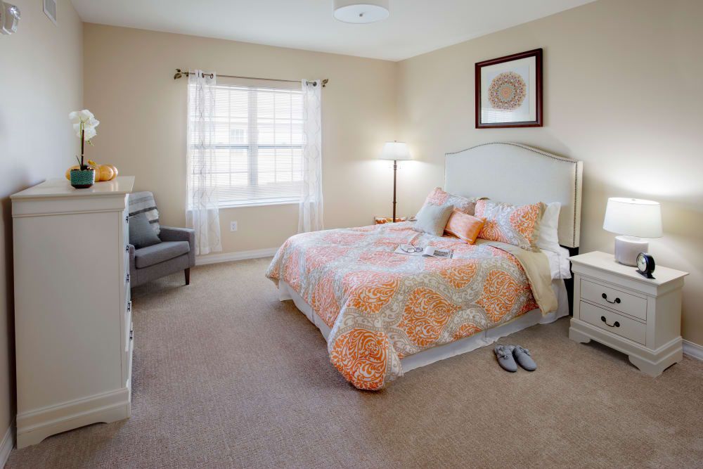 A cozy bedroom with a neatly made bed, soft lighting, and tasteful decor.
