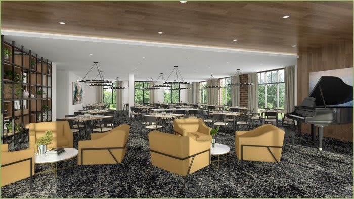 A modern restaurant interior with lounge chairs, tables, and large windows.