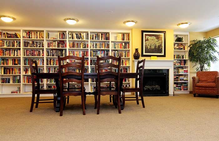 A cozy home library with bookshelves and a dining area.