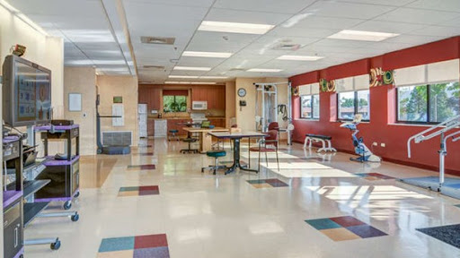 A spacious and well-lit waiting area featuring tables and chairs in a modern design.