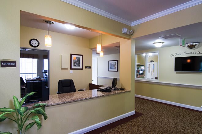 A well-lit office reception area with a desk and hallway in view.