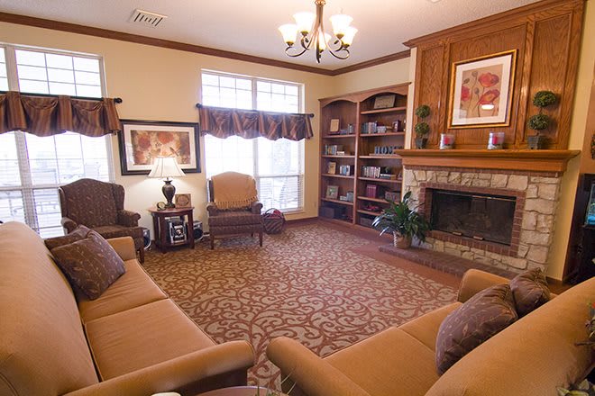 A cozy living room with comfortable seating, a fireplace, and built-in bookshelves.