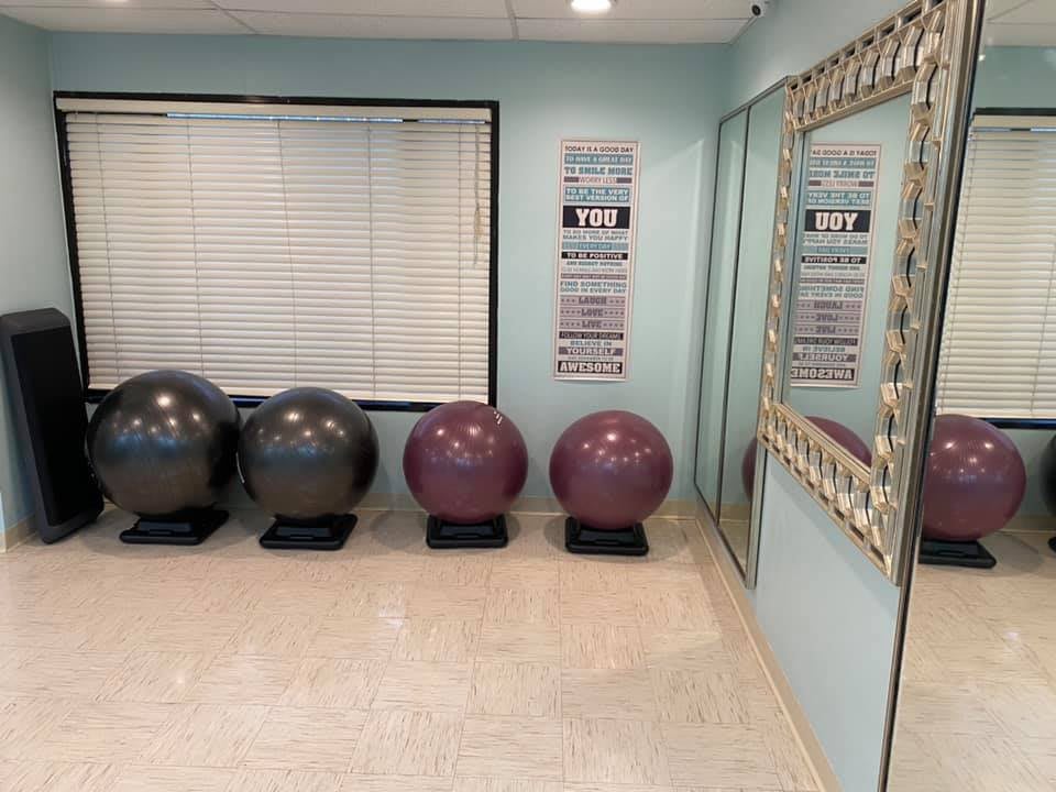 A fitness room with exercise balls and motivational posters.