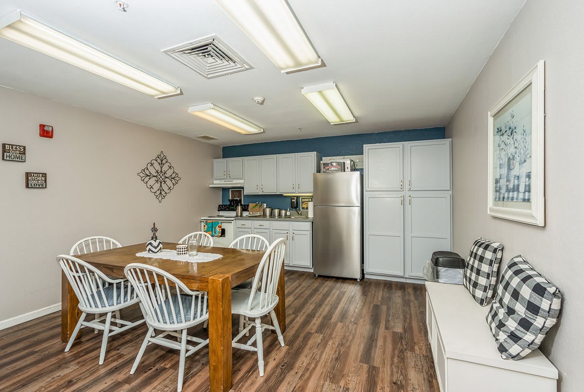 A cozy kitchen and dining area featuring a wooden table with chairs, modern appliances, and ample cabinet space.