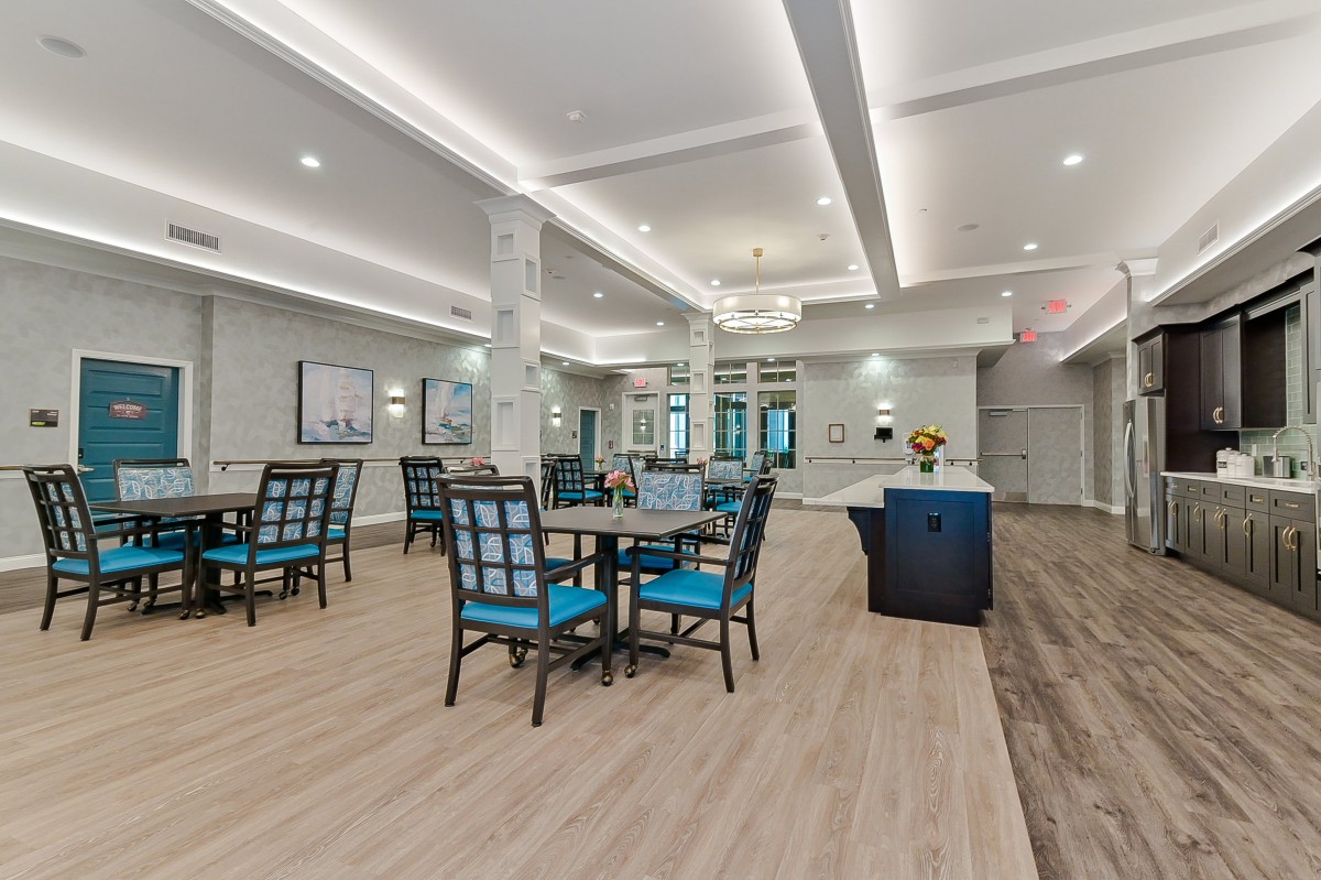 A modern dining area featuring neatly arranged tables and chairs, with elegant lighting and decor.