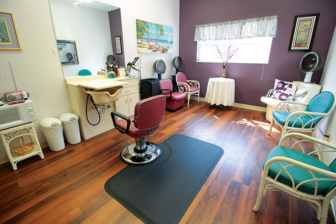 A cozy hair salon with a styling station and comfortable seating.