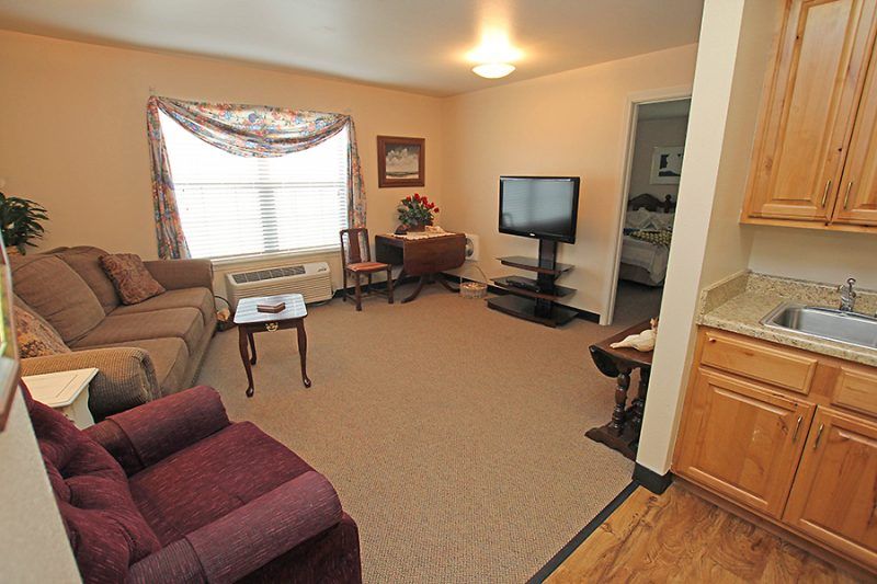 A cozy living room with a sofa, television, and coffee table.