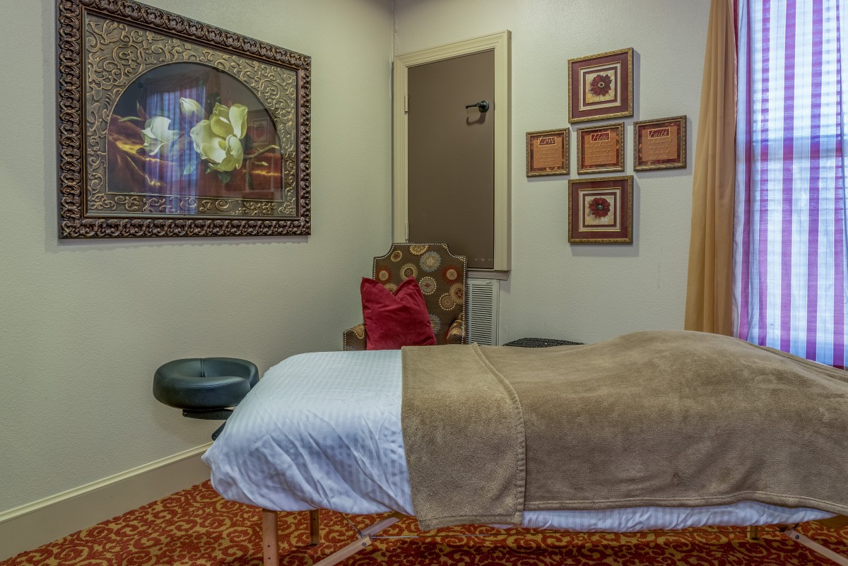 A tranquil massage room with calming decor and a therapy bed.