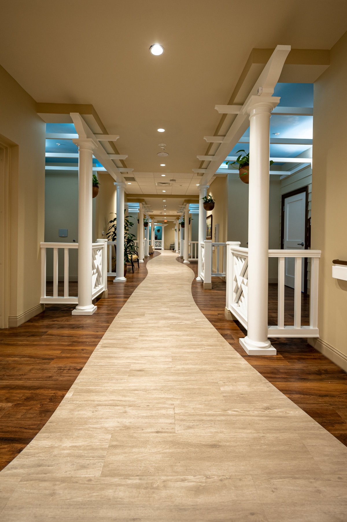 A beautifully designed hallway featuring classic columns and warm wood flooring.