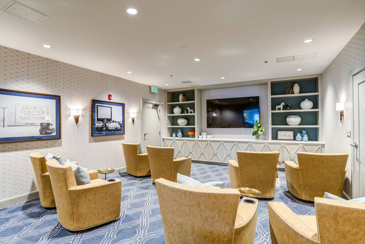 A modern lounge area with comfortable chairs and a large television screen.