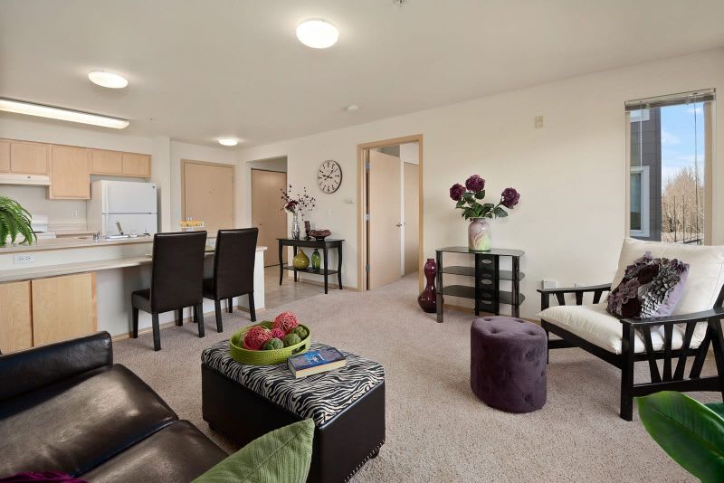 A modern living room with an open floor plan, featuring a cozy seating area and adjacent dining space.