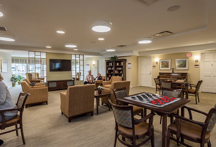 A cozy lounge area with comfortable seating, a television, and a table set up for board games.