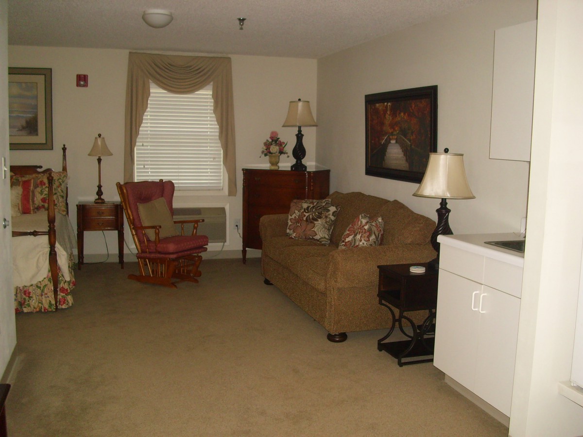 A cozy living room with a sofa, armchair, and decorative lamps.