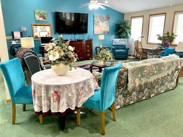 A cozy living room with floral accents, featuring a television and comfortable seating.