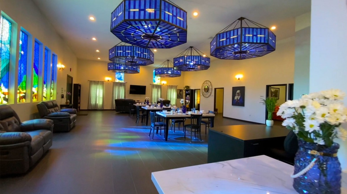 A modern restaurant interior with elegant blue chandeliers and a spacious dining area.