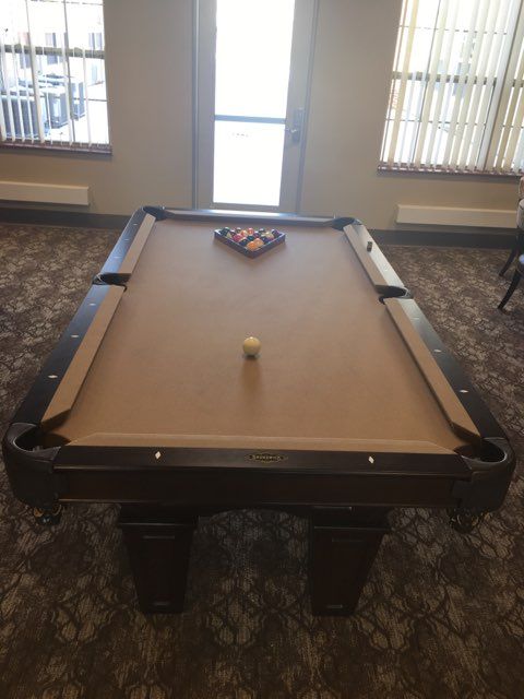 A pool table set up for a game in a well-lit room.