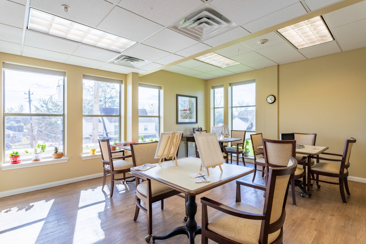 Bright and airy dining area with tables and chairs near large windows.