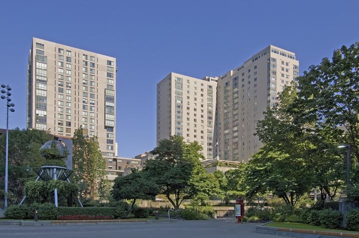 A view of tall residential buildings surrounded by trees in an urban setting.