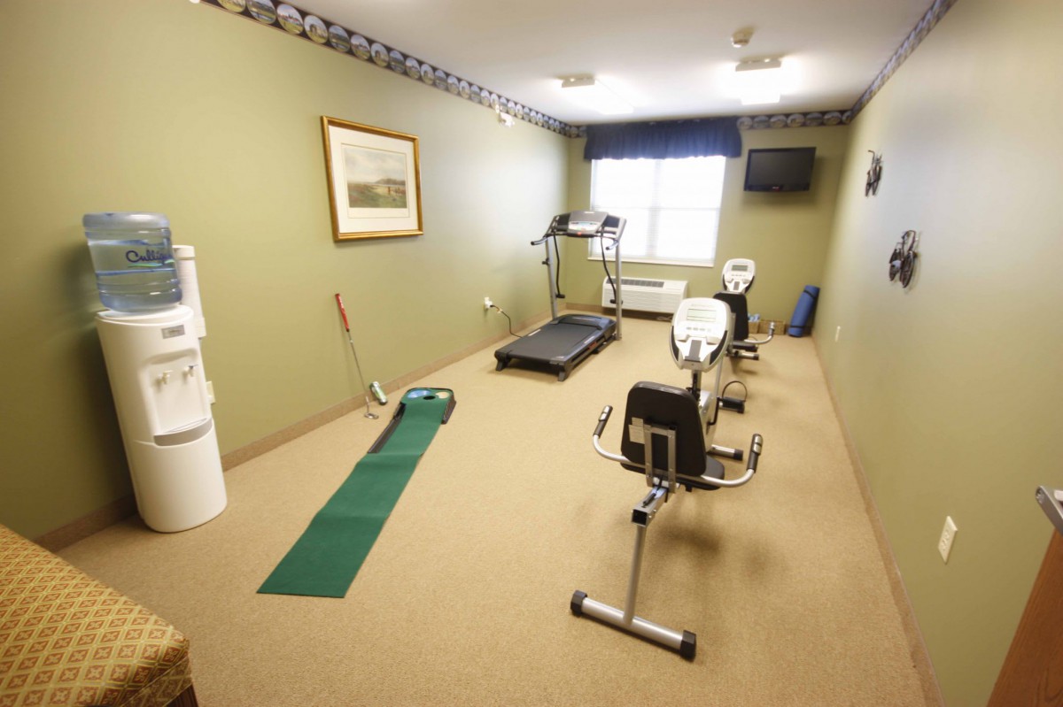 A small gym room with exercise equipment including a treadmill and stationary bike.