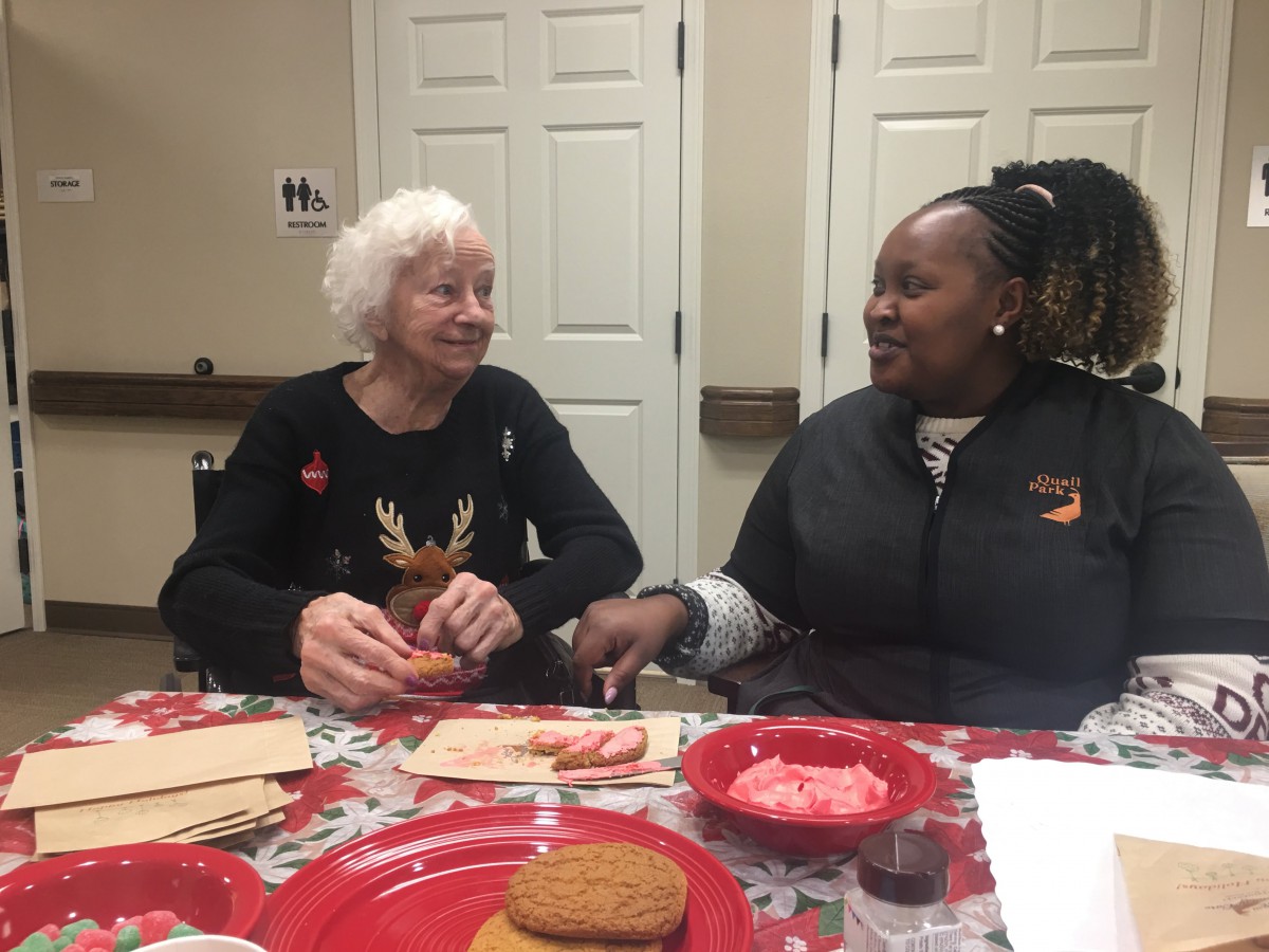 Two people sitting at a table, enjoying cookies and conversation.