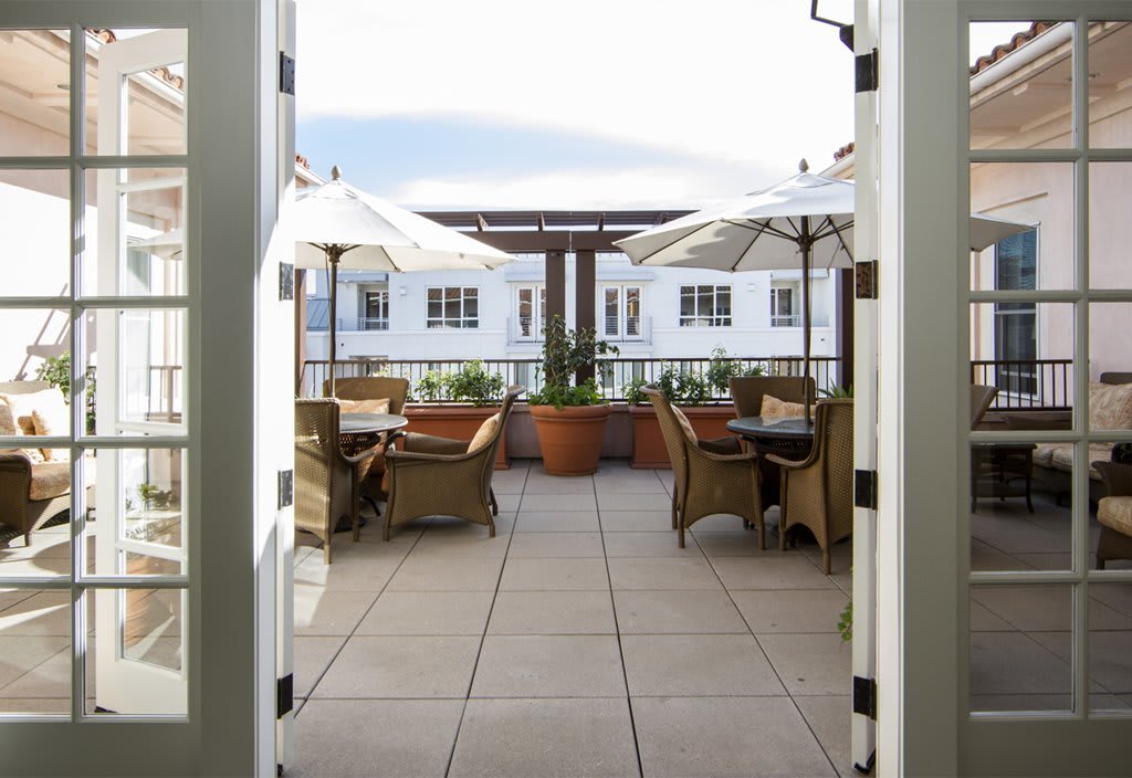 A scenic outdoor patio with tables, chairs, and umbrellas on a sunny day.