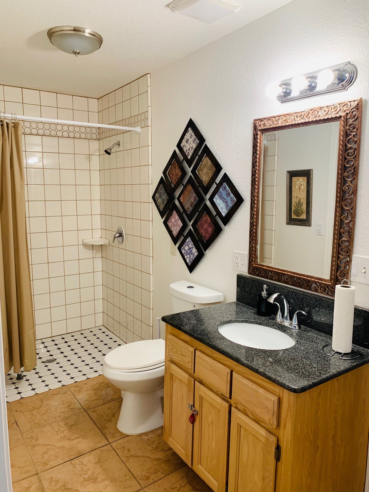 A neatly designed bathroom with a mirror, sink, toilet, and tiled shower area.