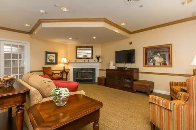A cozy living room featuring a fireplace, television, and comfortable seating arrangements.