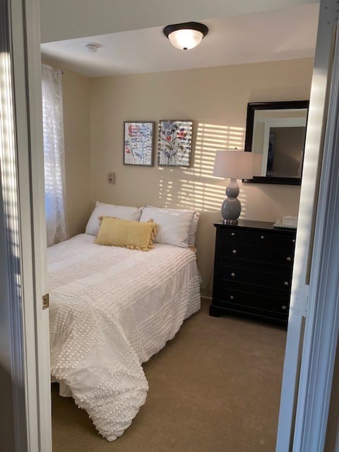 A cozy bedroom with a double bed, dresser, and decorative touches.