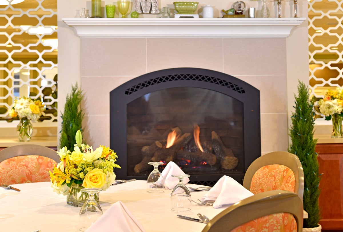 Elegant dining area with a cozy fireplace and a beautifully set table.
