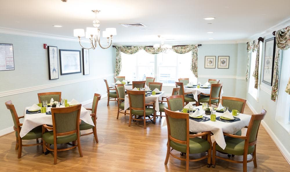 An elegant dining room with neatly arranged tables and chairs, featuring classic decor and wood flooring.