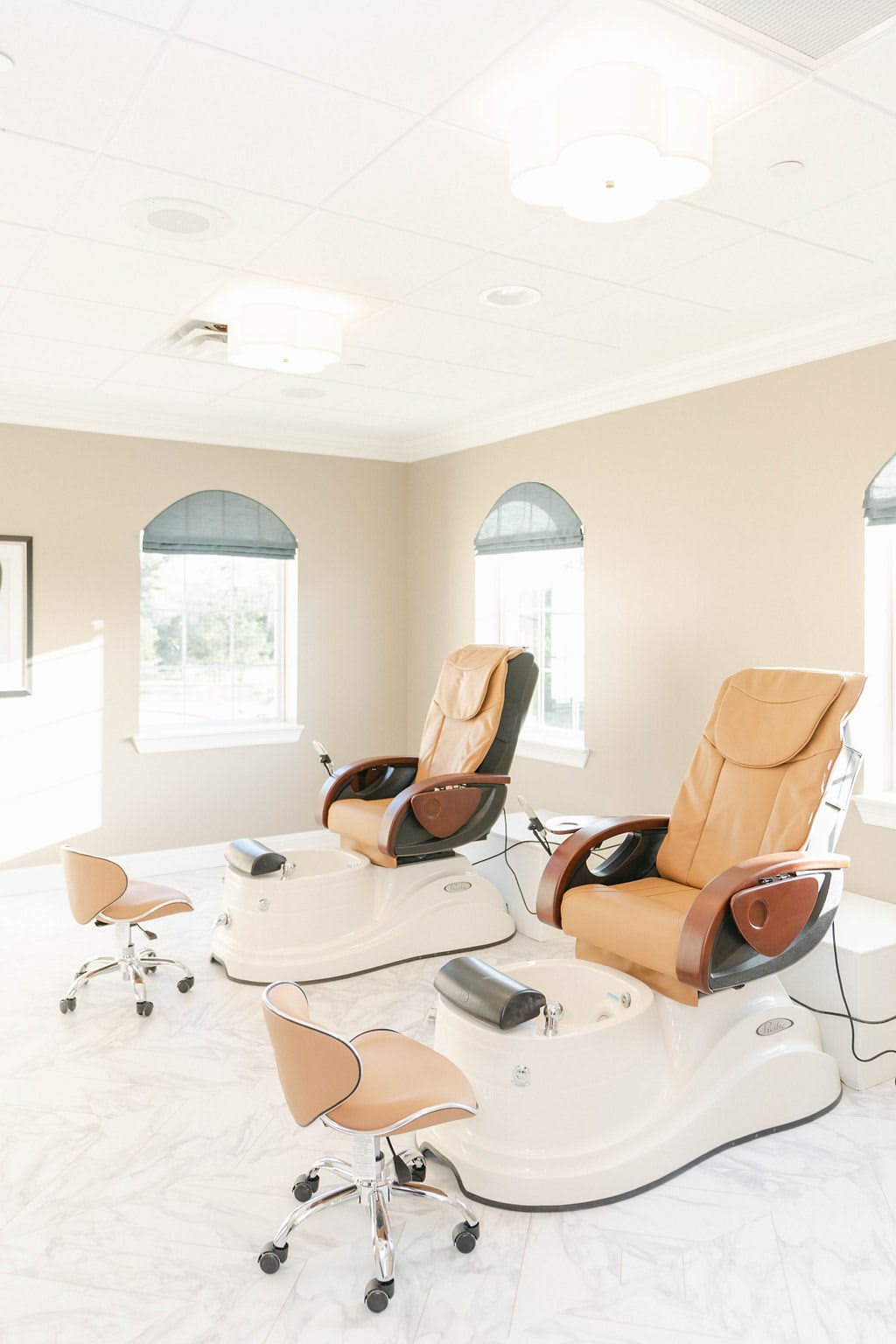 A bright and serene nail salon with comfortable pedicure chairs.