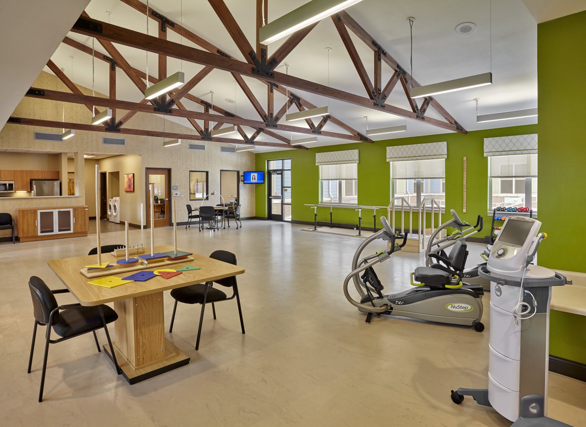 A spacious and modern rehabilitation center equipped with various exercise machines and therapy tools.