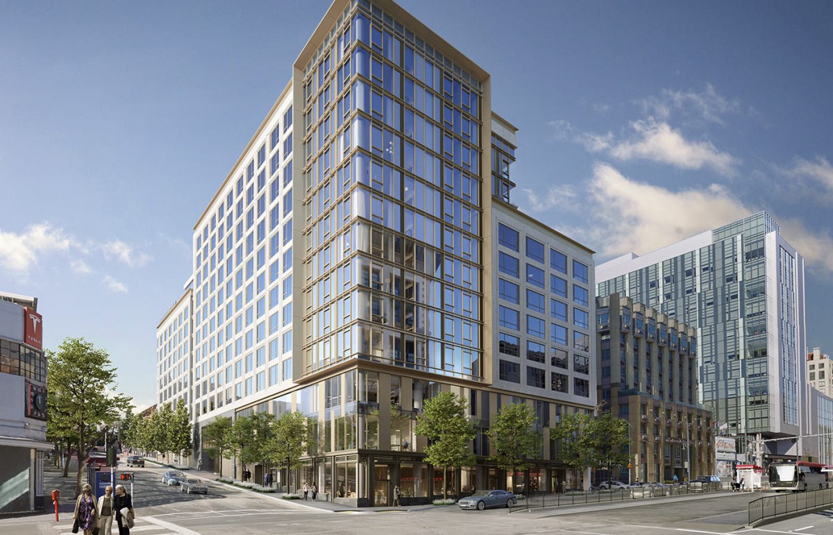 A modern office building with a glass facade located on a busy city street corner.