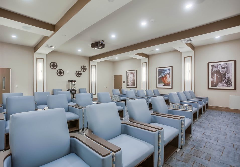 A modern waiting room with rows of comfortable blue chairs and stylish decor.