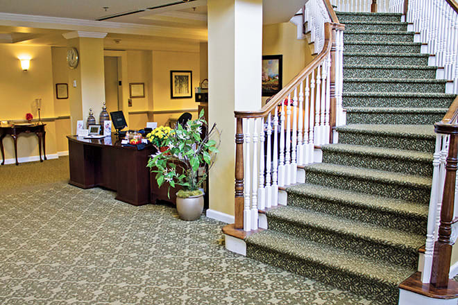 A well-decorated lobby area with a reception desk and staircase.