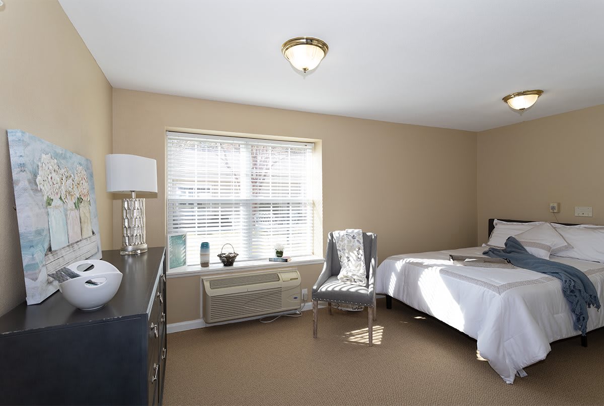 A cozy and neatly arranged bedroom with soft lighting and neutral tones.