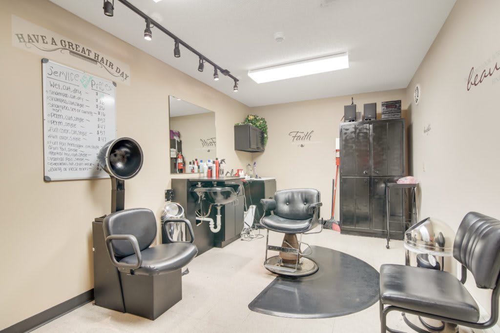 Interior of a hair salon with chairs, mirrors, and beauty equipment.
