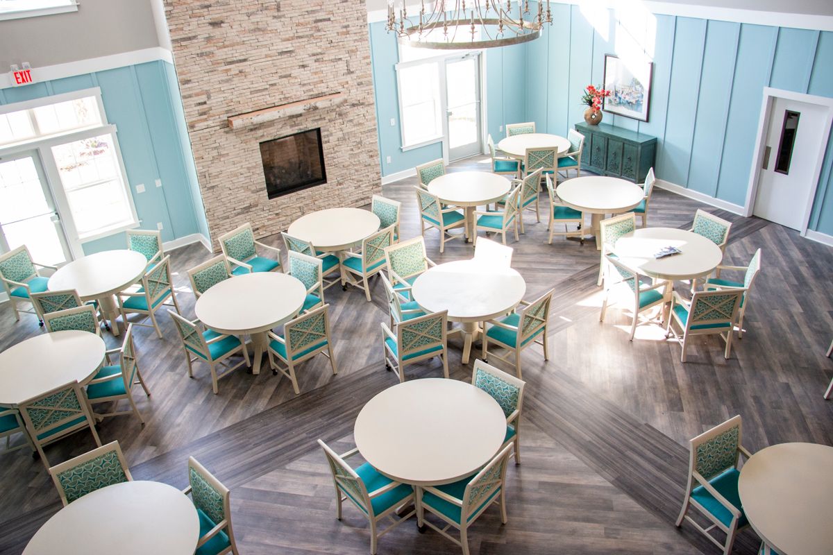 A modern dining area with round tables and chairs, featuring bright lighting and stylish decor.
