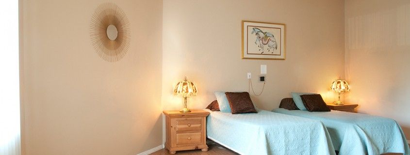A cozy bedroom with a single bed, nightstand, and decorative lamp.