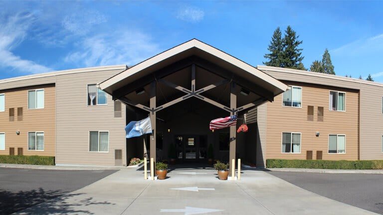 Entrance of a building with a covered walkway and flags.
