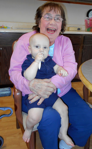 A joyful moment shared between a baby and an elderly woman.