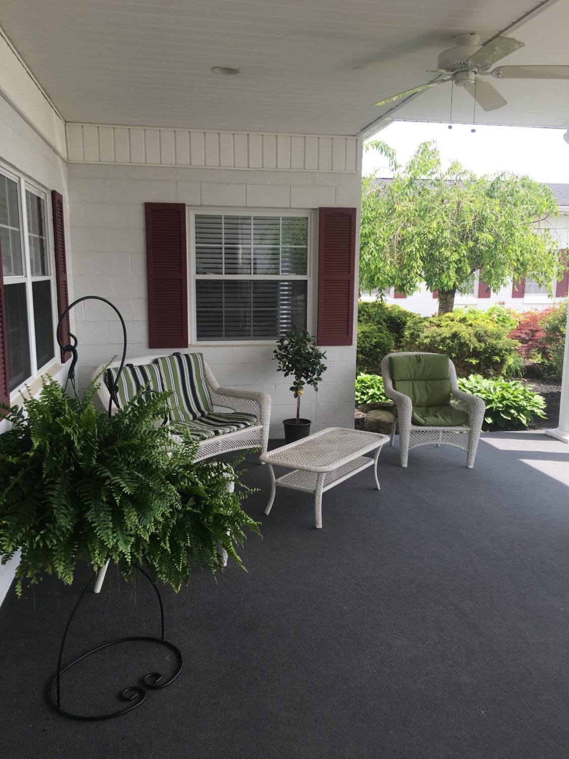 A cozy porch with comfortable seating and lush greenery.