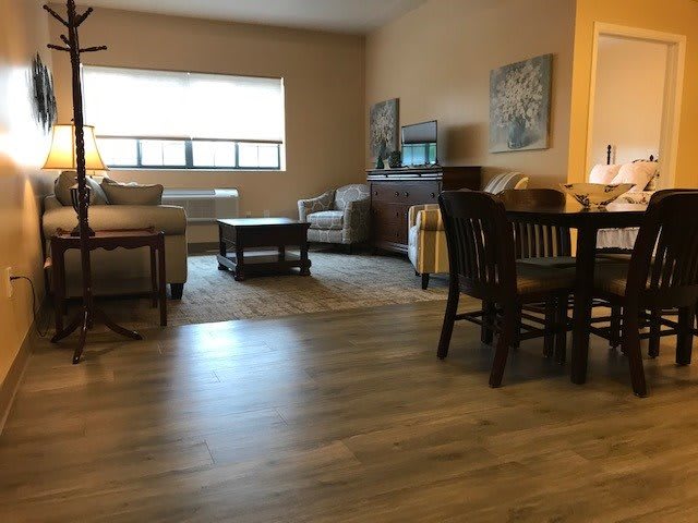 A cozy living room with a sofa, coffee table, and dining area.