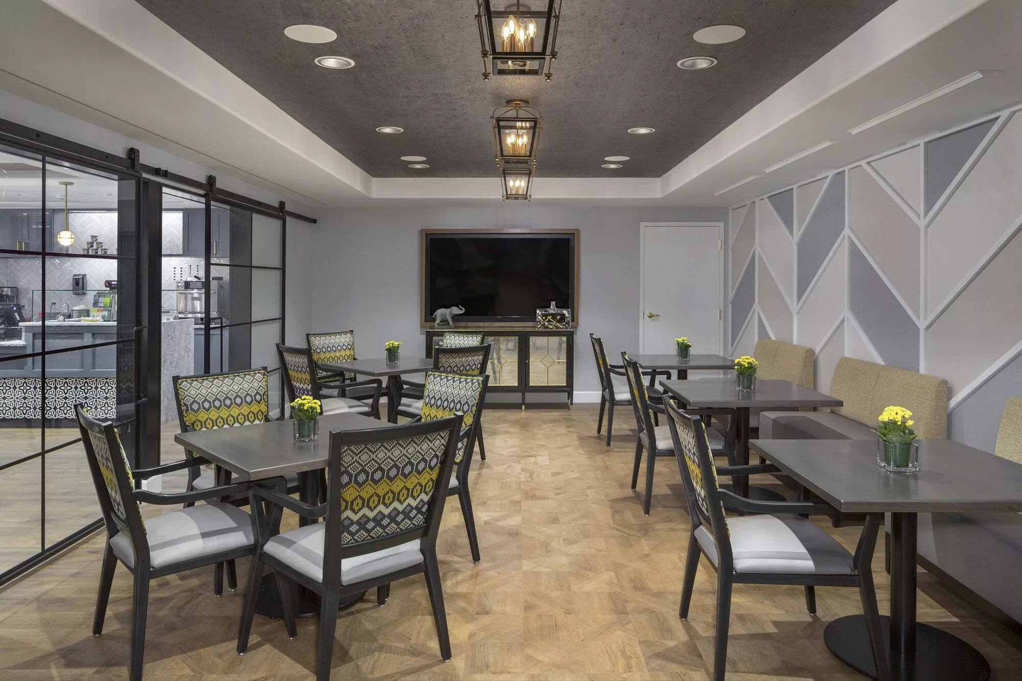 A modern dining area with stylish tables and chairs, featuring elegant lighting fixtures.
