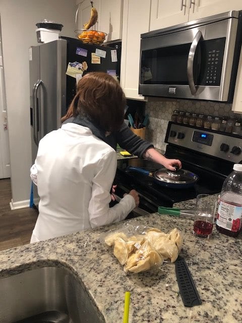 Two people cooking together in a home kitchen.