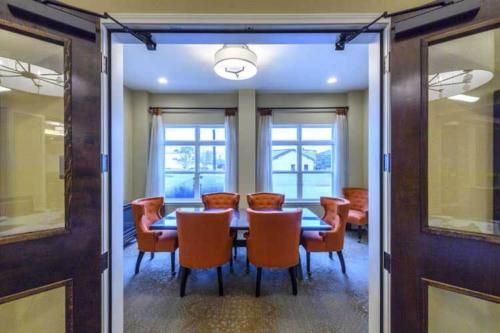 A well-lit conference room with orange chairs and a central table.