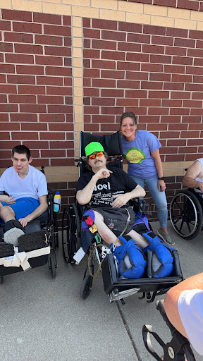 A cheerful group of friends enjoying a day outside, each in their wheelchairs, showcasing camaraderie and joy.